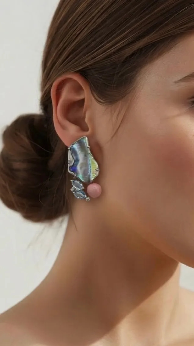 Sculptural abalone and coral earring, worn, seen from the side