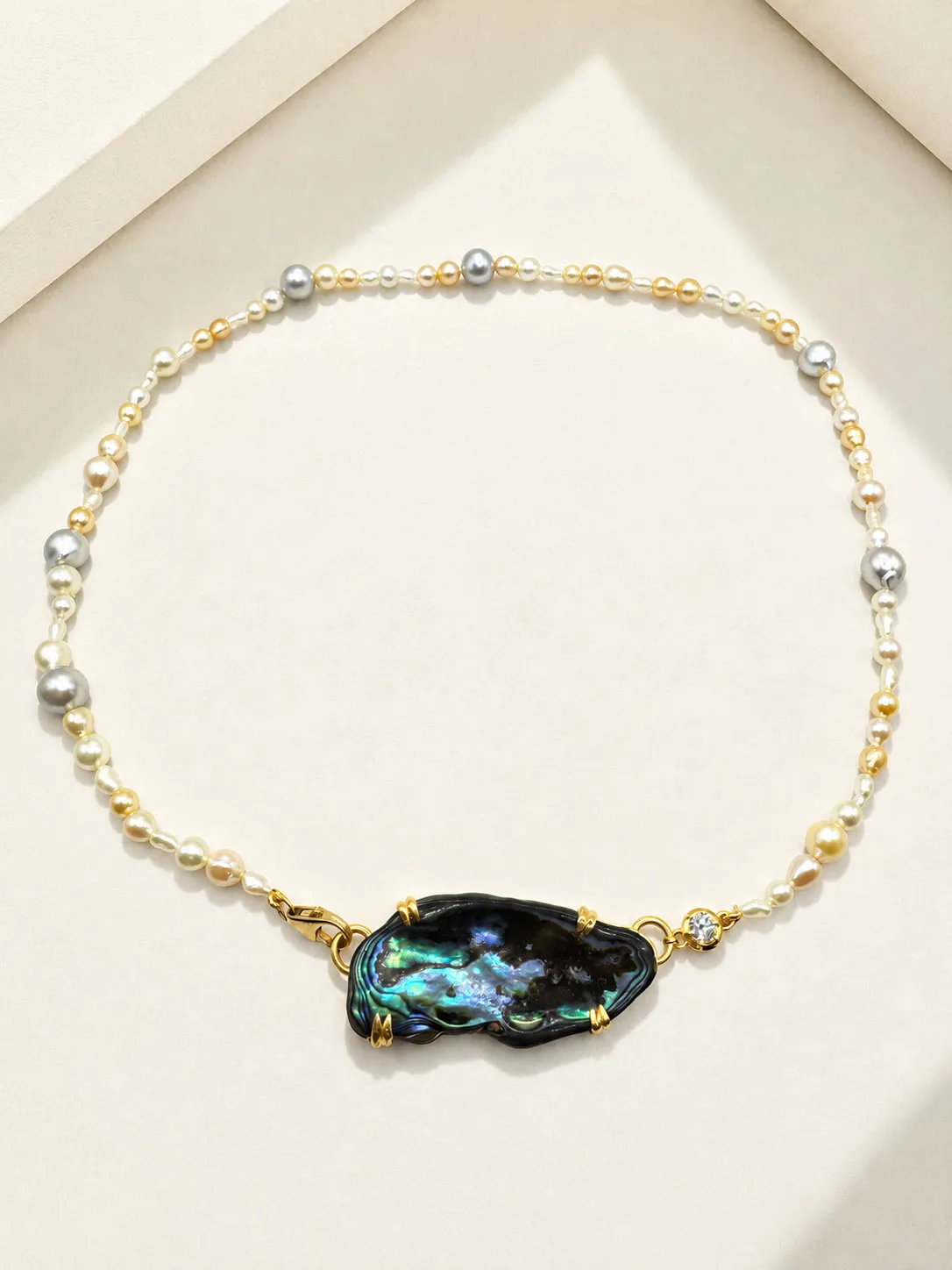 Necklace of golden, white and grey pearls with a baroque abalone centrepiece set in gold