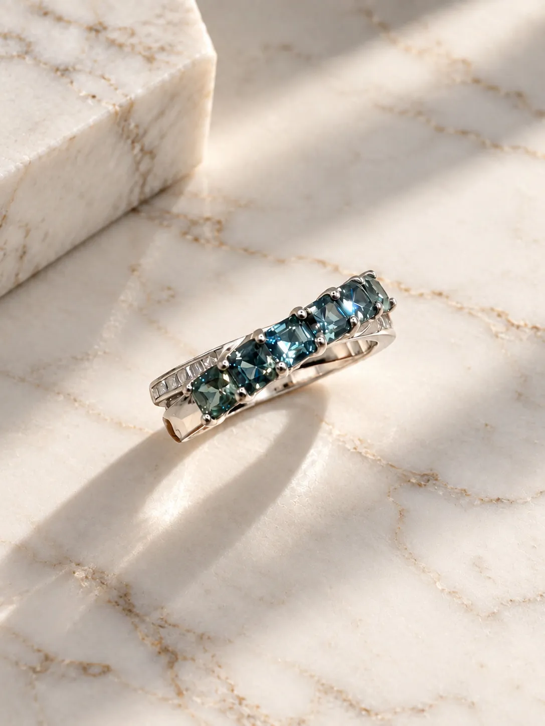 Ring set with a row of blue gemstones on marble