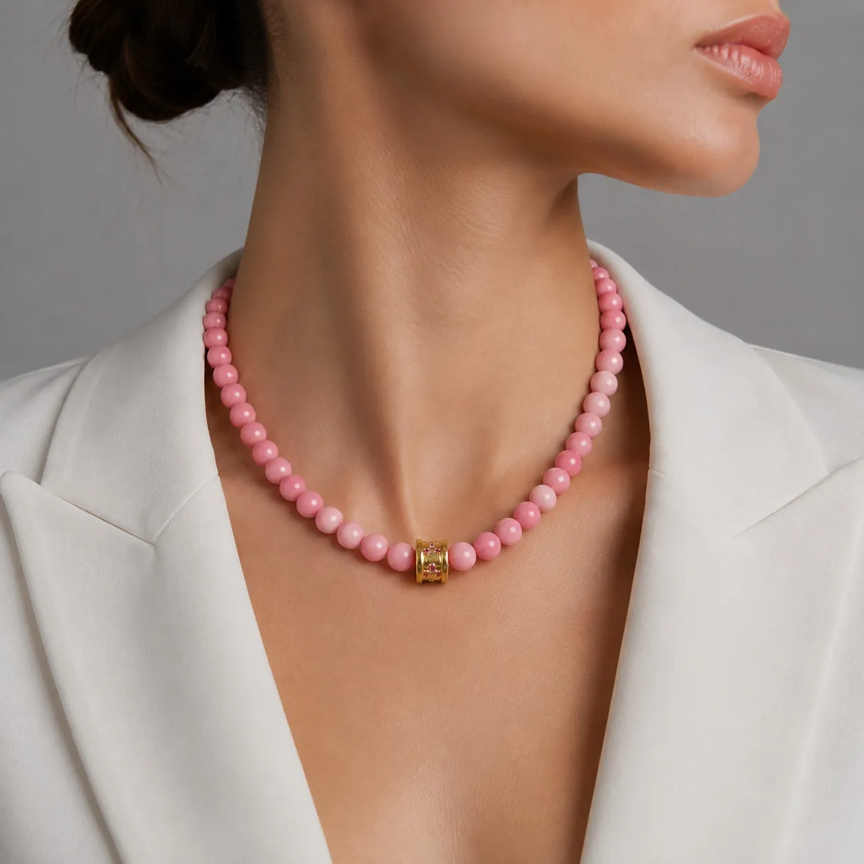 Pink coral bead necklace worn with a white jacket