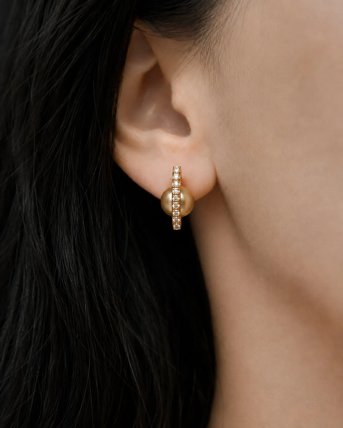 Golden pearl hoop earring worn