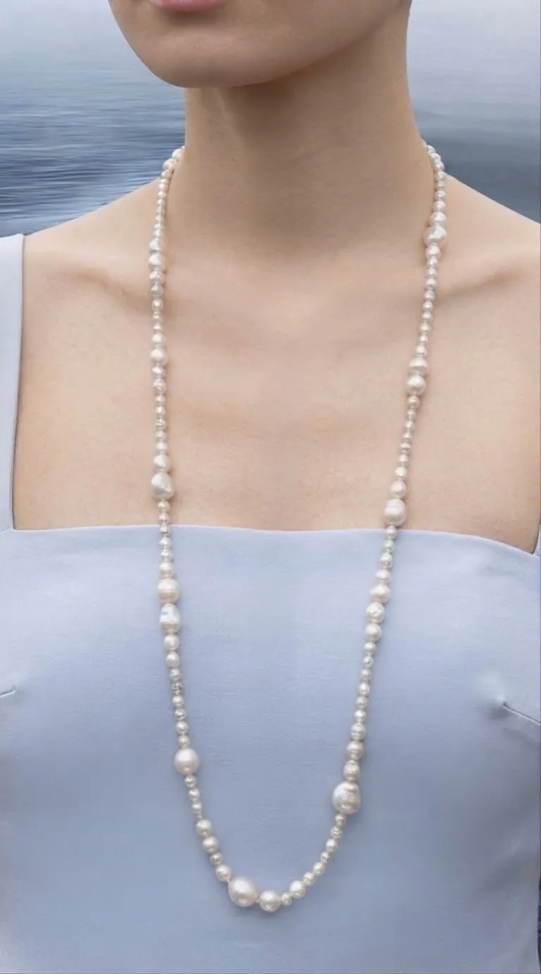 Long pearl necklace worn against the sea