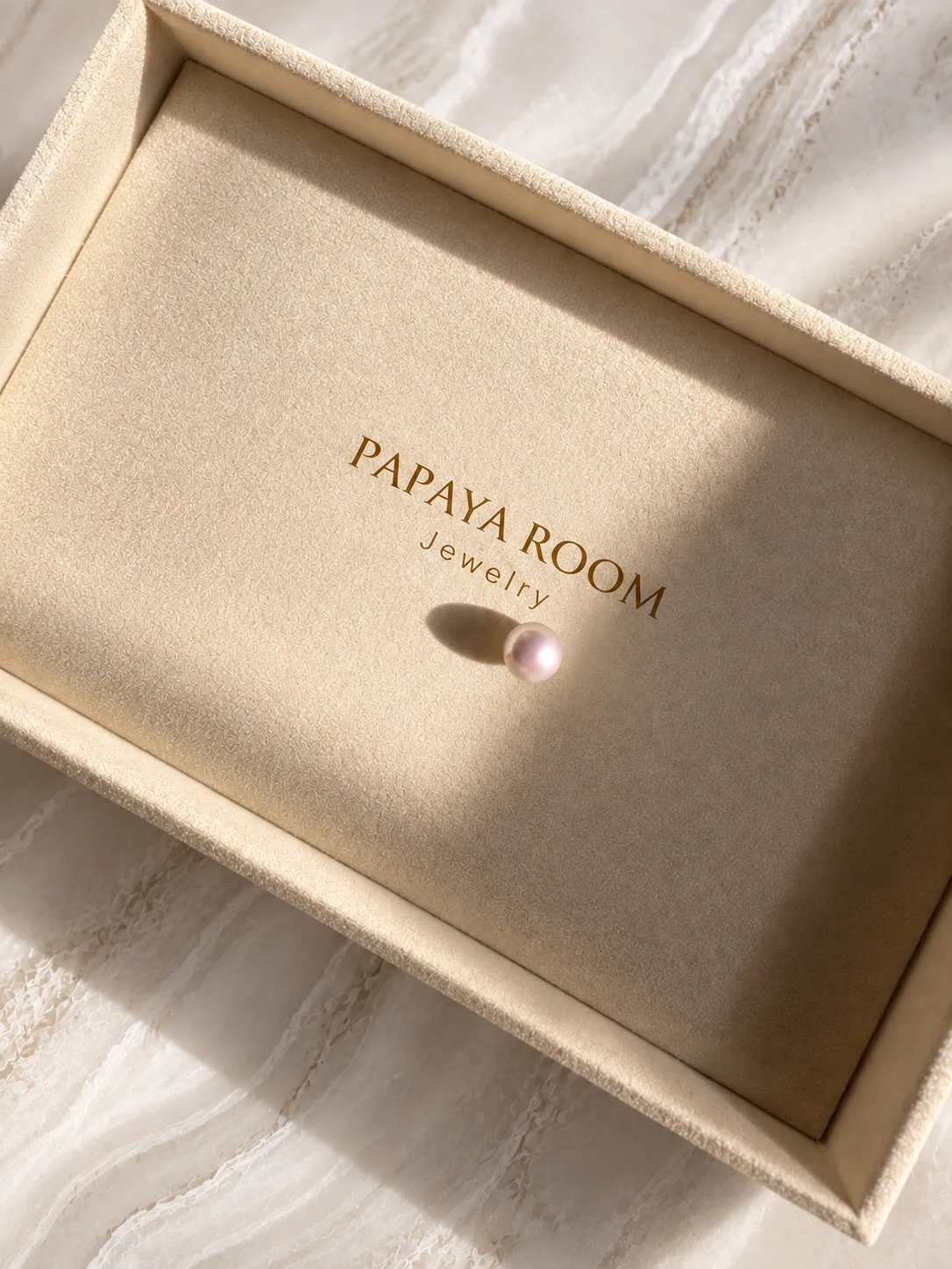 A single pearl resting in a Papaya Room jewelry tray
