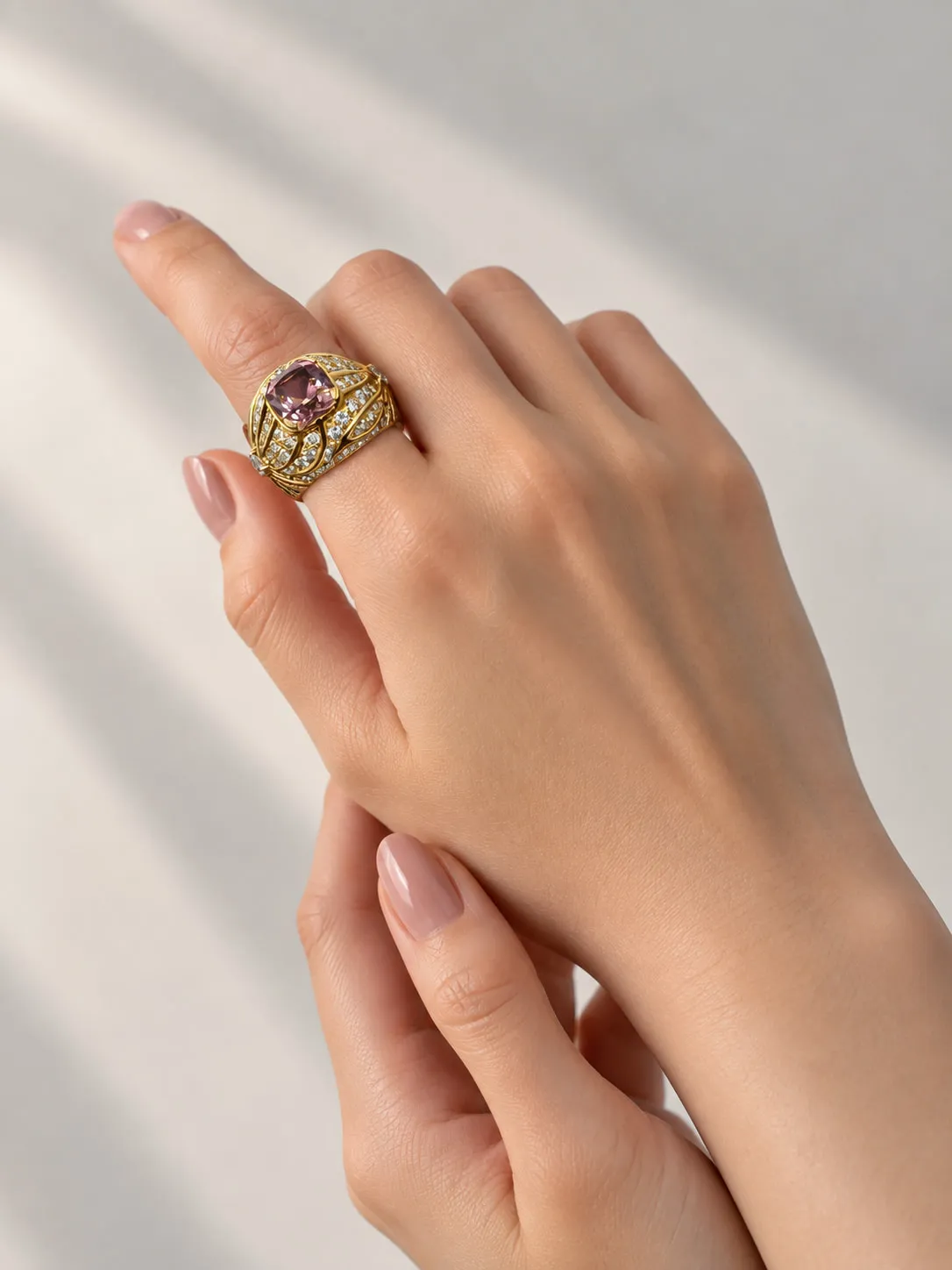 Gold cocktail ring with a pink gemstone, worn